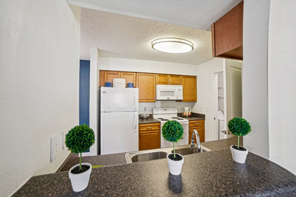A kitchen with granite countertops and a white refrigerator at Willow Ridge Apartments, North Carolina, 28210