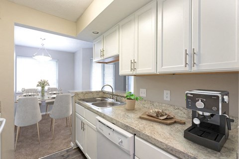 a kitchen with white cabinets and a coffee maker on the counter
