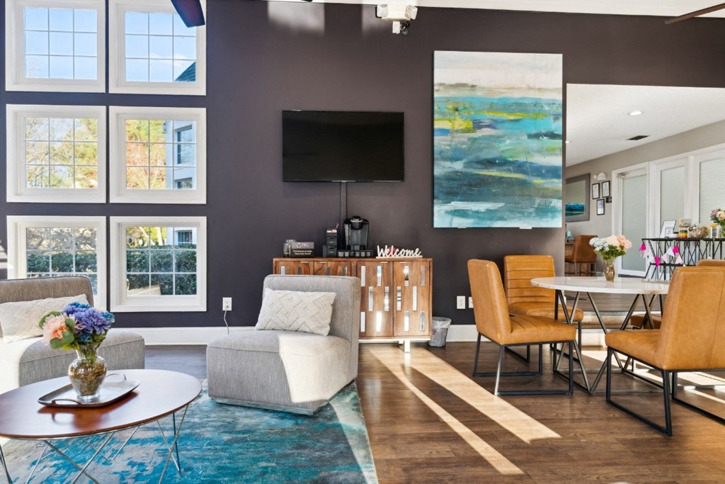 a living room with a couch and chairs and a table and a television