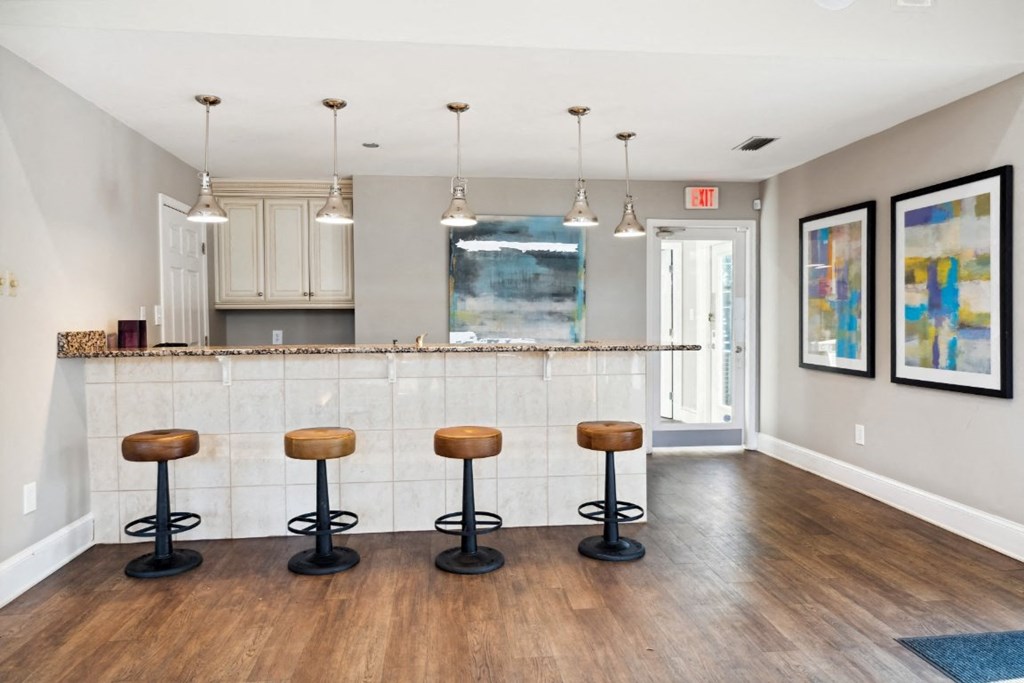 a kitchen with a bar and stools in a living room