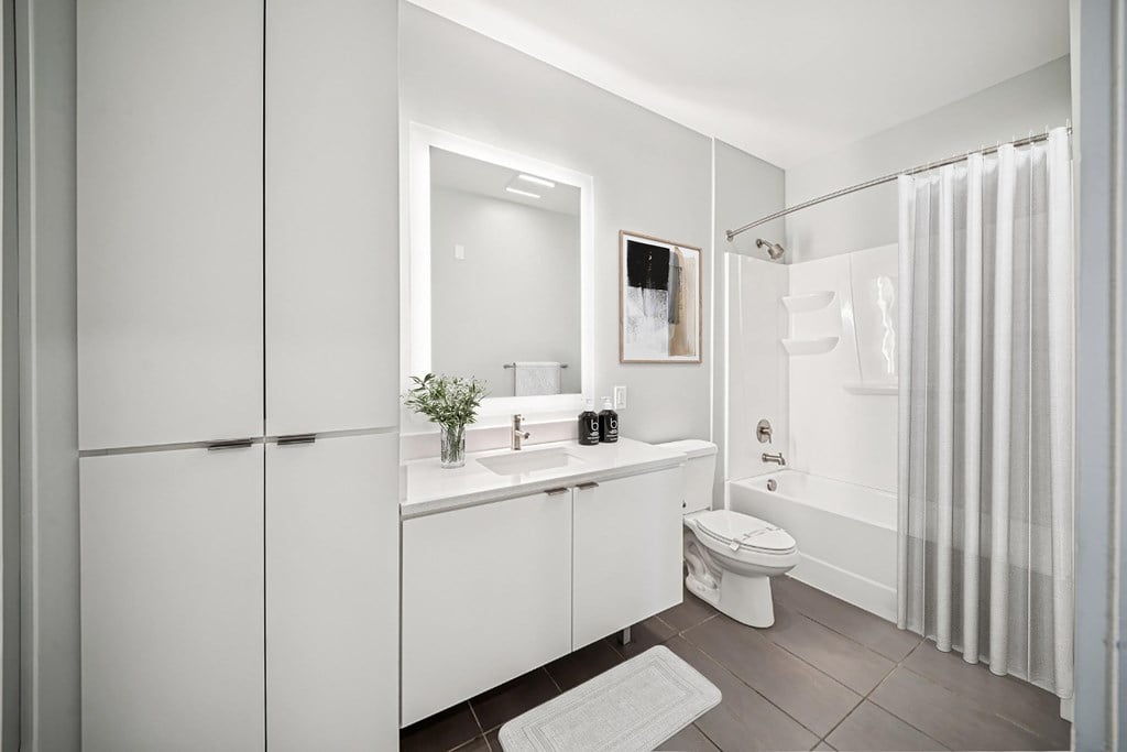 A white bathroom with a toilet, sink, and shower.