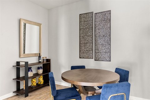 Dining room with round table and blue chairs at Citrus Tower Apartments, Clermont, FL 34711