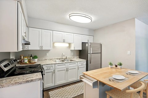 A kitchen with a table set for two.