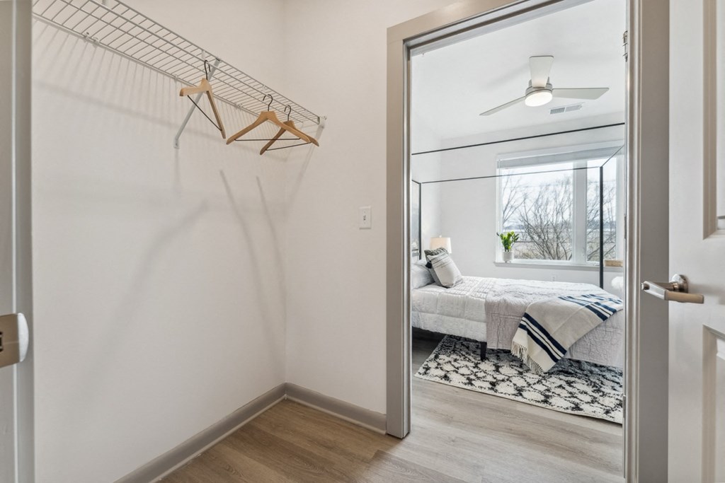 a bedroom with white walls and hardwood floors