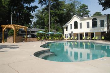 a swimming pool with a house in the background at Clarion Crossing Apartments, PRG Real Estate Management, Raleigh