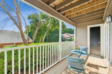 A small balcony with a table and two chairs. at Woodcreek Apartments, Cary