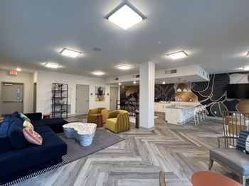 A spacious room with a variety of seating options and a patterned carpet.