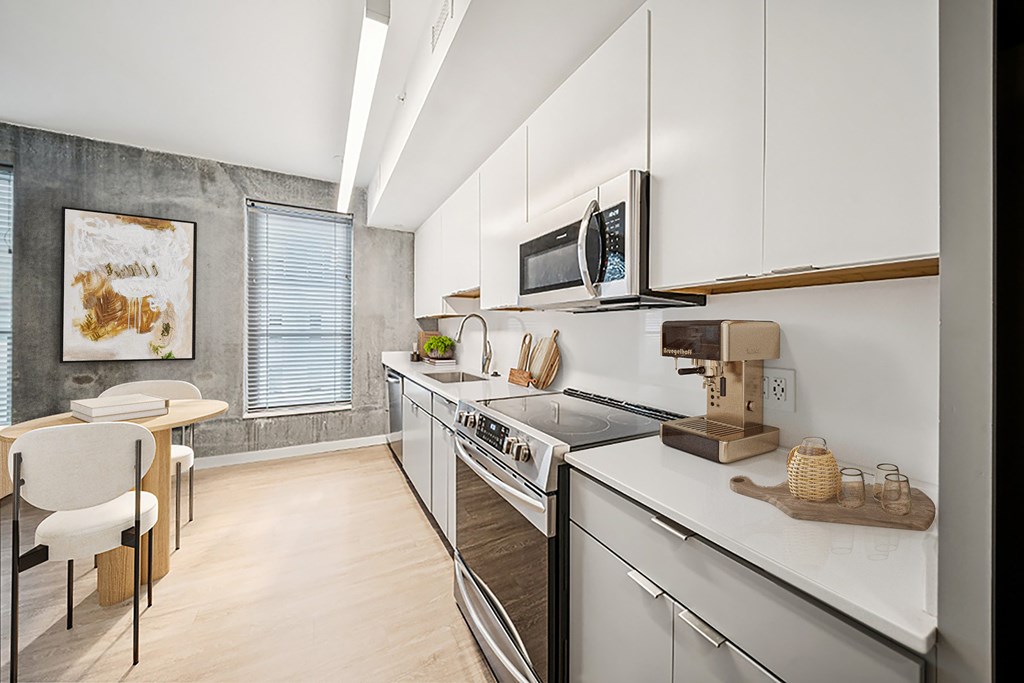 A modern kitchen with white cabinets and stainless steel appliances.