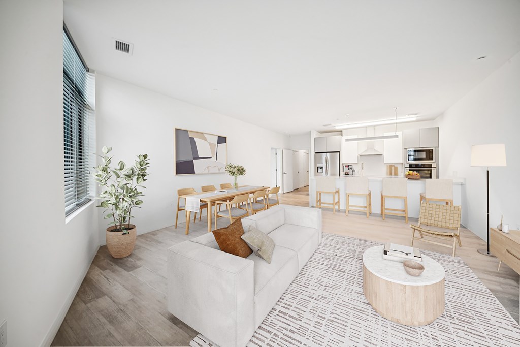 A living room with a white couch and a wooden coffee table.