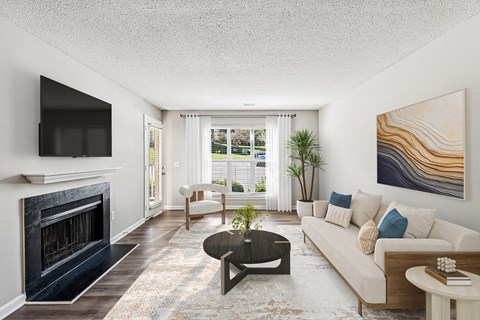A living room with a fireplace and a painting on the wall.