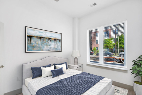 a bedroom with a large bed and two windows at The Point Apartments on 38th, Norfolk, VA