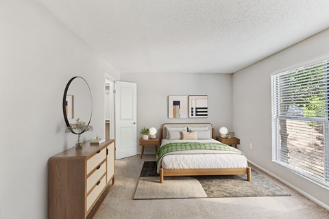 A bedroom with a bed, nightstand, and a mirror on the wall at Beacon Ridge Apartments, PRG Real Estate Management, Greenville, 29615