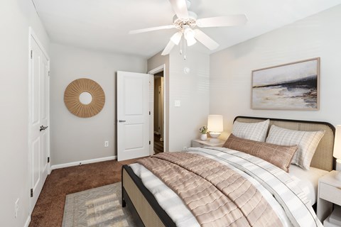 A bedroom with a large bed and a painting on the wall at Rivers Landing Apartments, Virginia, 23666