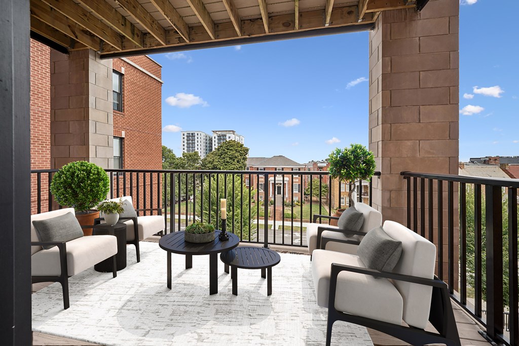 A patio with a table and chairs overlooking a city.