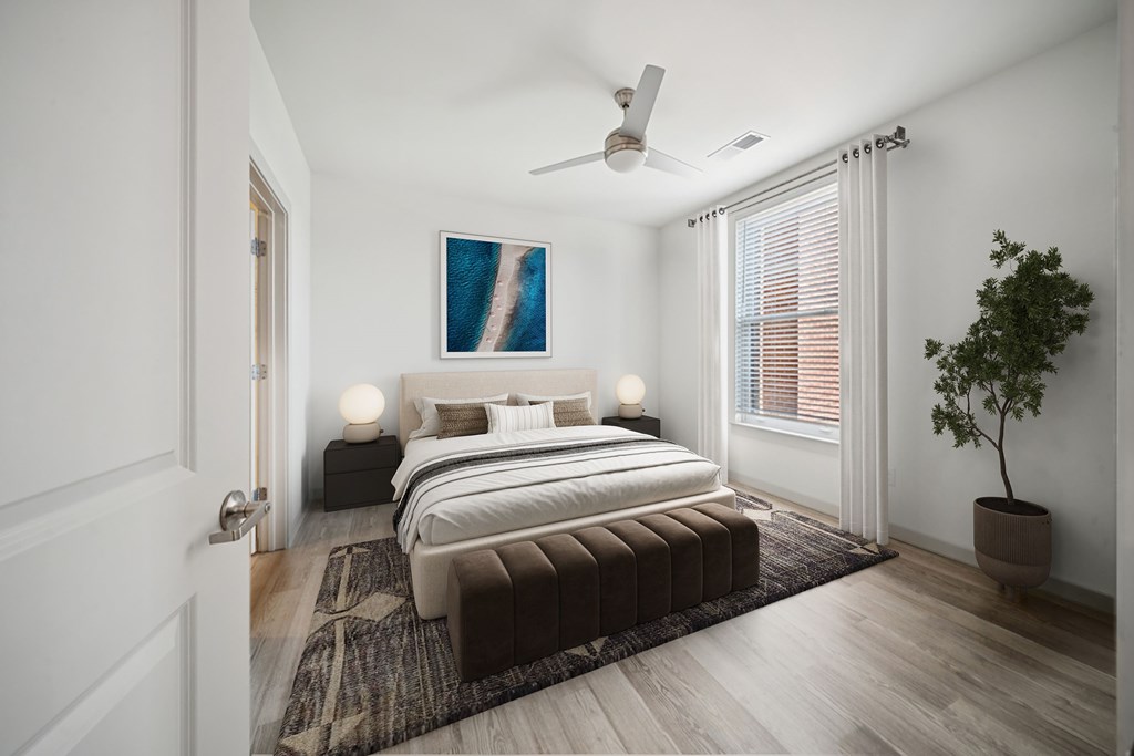 A bedroom with a large bed and a ceiling fan.