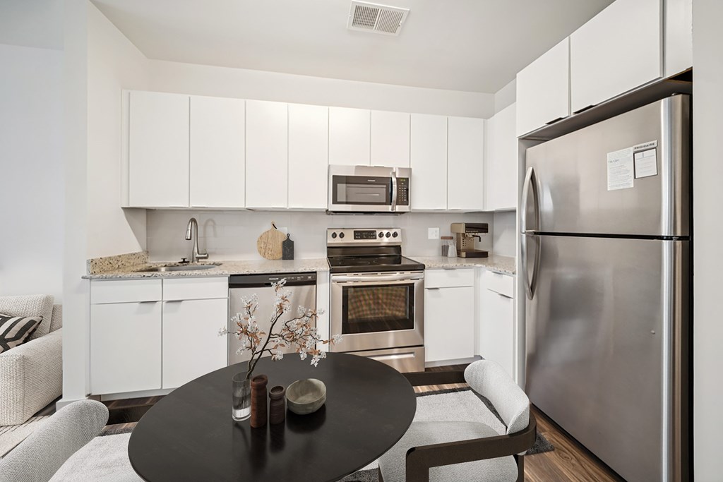 A modern kitchen with a refrigerator, oven, and microwave.