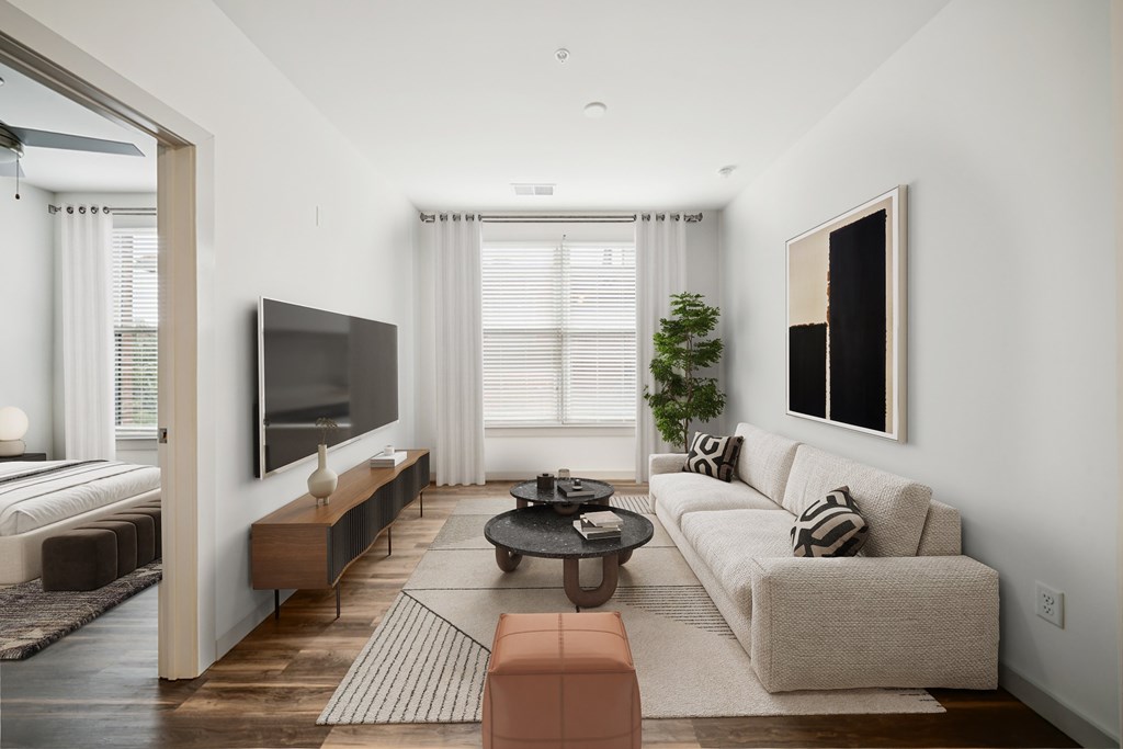 A modern living room with a large couch, a flat screen TV, and a coffee table.
