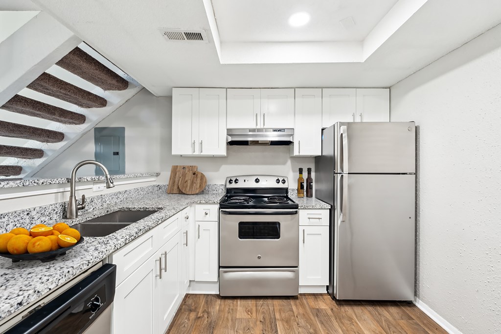 A modern kitchen with a stainless steel refrigerator and a black dishwasher at Woodcreek Apartments, Cary, 27511