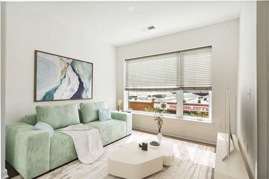 a living room with a green couch and a large window