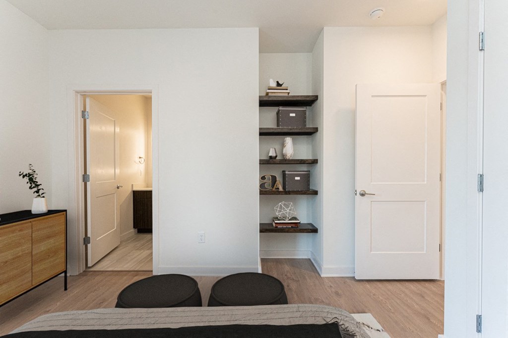a bedroom with white walls and a bed with two black pillows