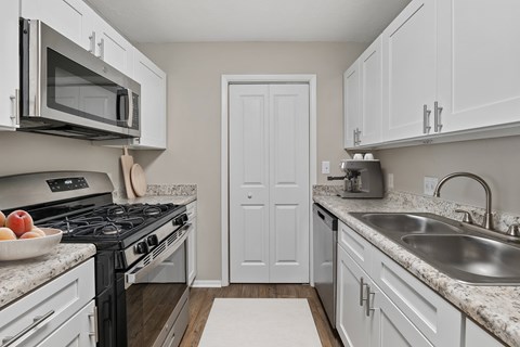 A kitchen with a black stove top oven and a white door.