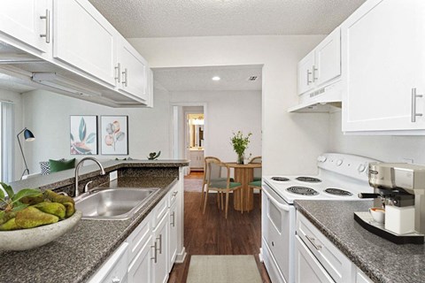 a kitchen with white cabinets and granite counter tops