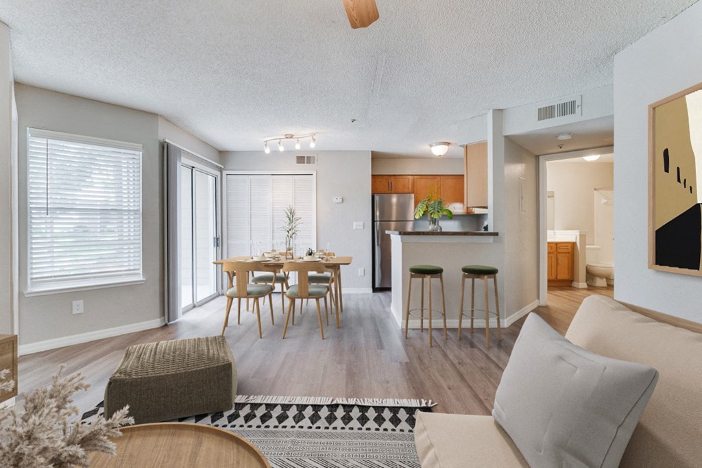 living room with a table and chairs and a kitchen at Palm Crossing Apartments in Winter Garden, FL