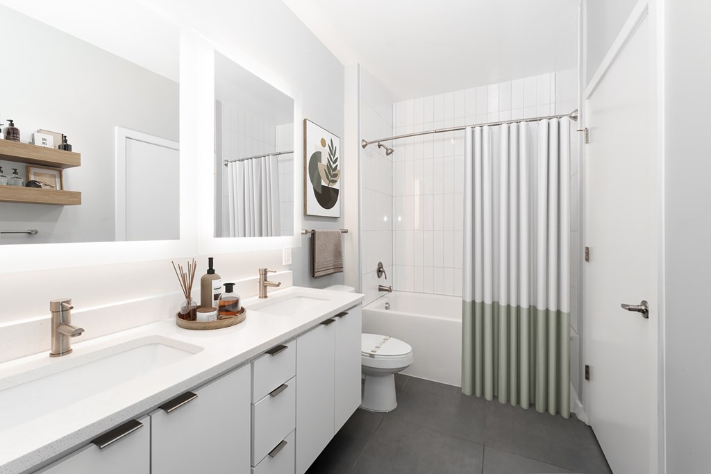 A white bathroom with a toilet, sink, and shower.