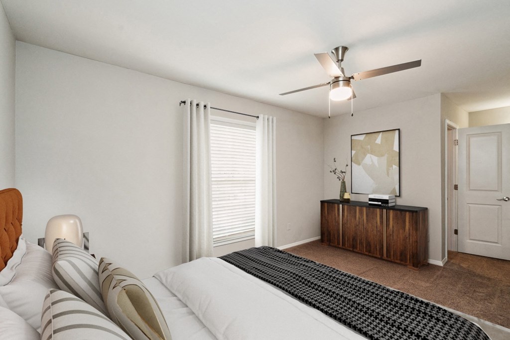 a bedroom with a large bed and a ceiling fan  at Lake Johnson Mews, Raleigh, 27606
