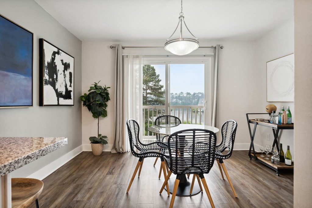 a dining area with a table and chairs and a large window with a view of the water a dining area with a table and chairs and a large window with a view of the water at Linkhorn Bay Apartments, Virginia Beach
