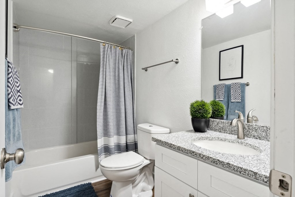 a bathroom with a white toilet next to a white bathtub at Linkhorn Bay Apartments, Virginia, 23451