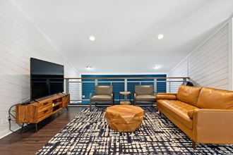 a living room with a leather couch and chairs and a flat screen tv on the wall a living room with a leather couch and chairs and a flat screen tv on the wall