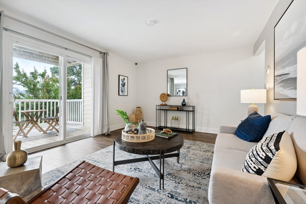 a living room with a sliding glass door that leads to a balcony at Linkhorn Bay Apartments, Virginia Beach, VA