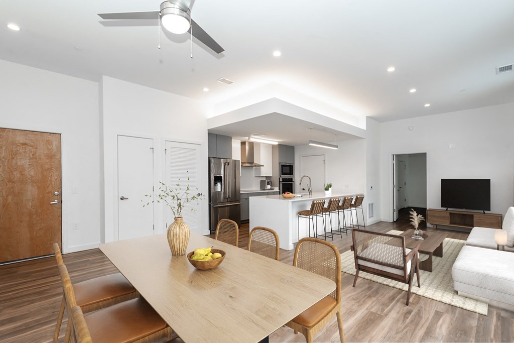 A modern dining room with a wooden table and chairs.