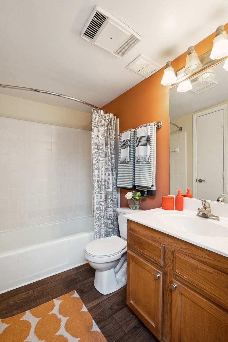 a bathroom with orange walls and a white bathtub  at Lake Johnson Mews, Raleigh