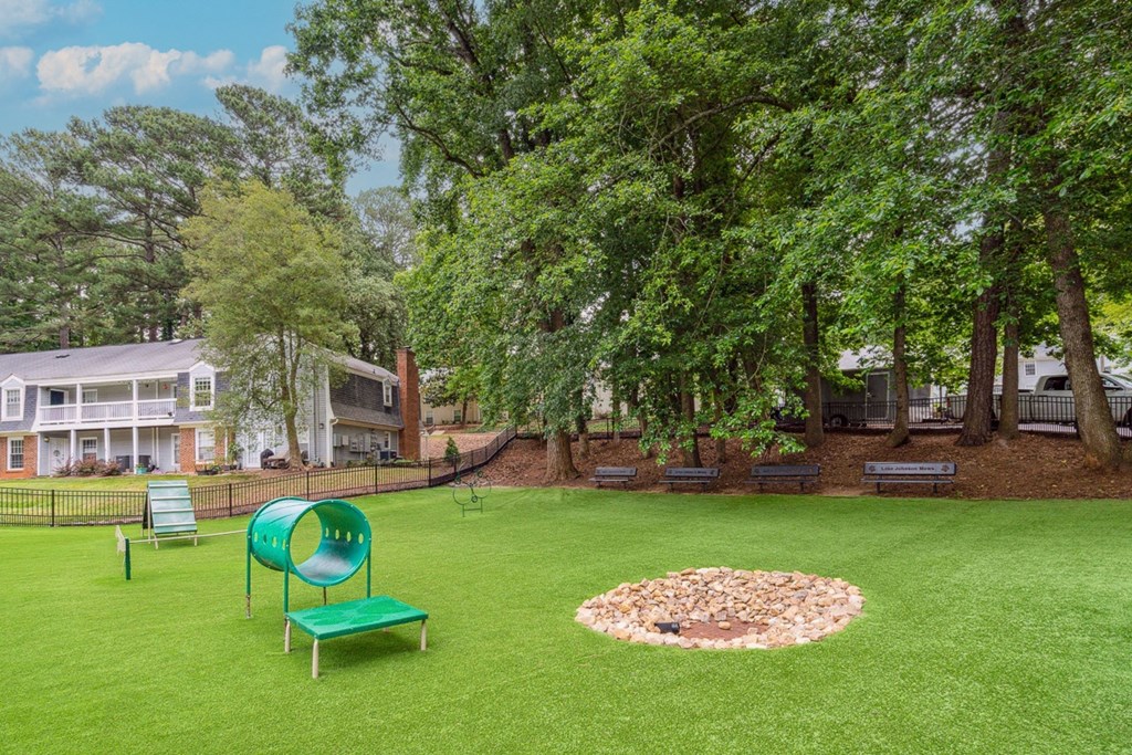 a large grassy area with a fire pit and benches  at Lake Johnson Mews, Raleigh, NC, 27606