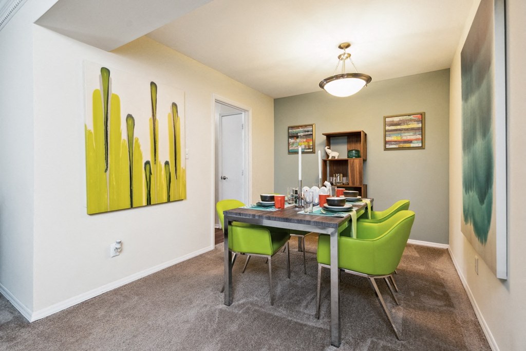 a dining room with a table and chairs and a painting on the wall  at Lake Johnson Mews, Raleigh, 27606