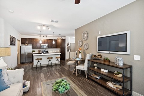 Living Room with TV and Kitchen in the Background at The Loree, Jacksonville, FL, 32256