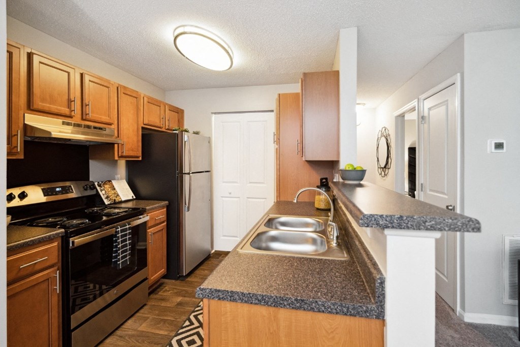 a kitchen with wood cabinets and granite countertops a kitchen with wood cabinets and granite countertops at Park Ridge Estates, Durham, NC, 27713
