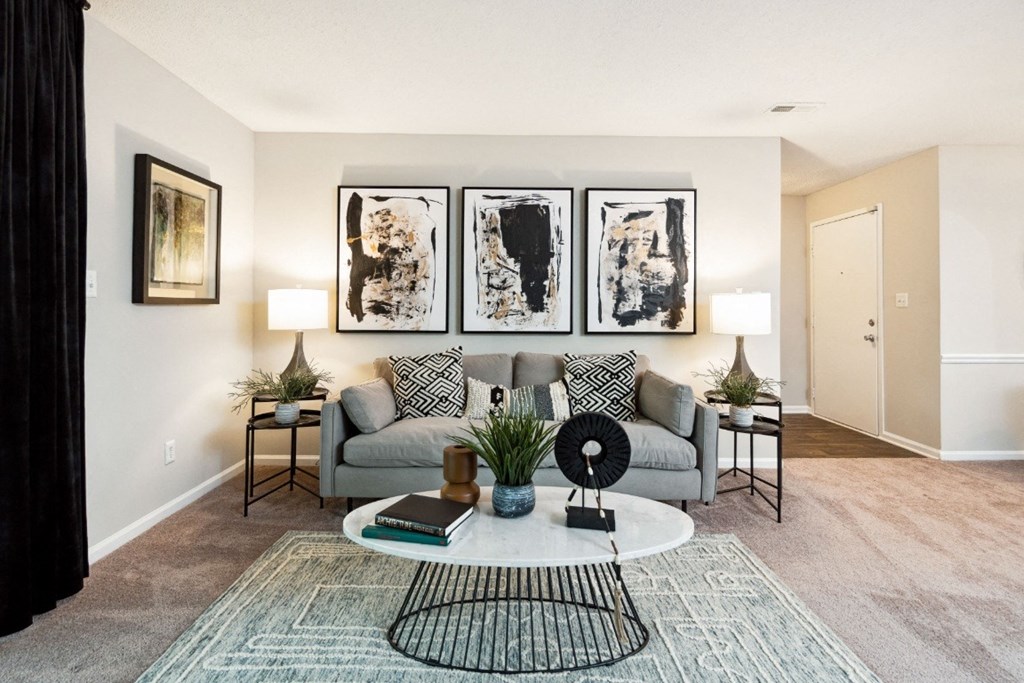 a living room with a grey couch and a white coffee table  at Park Ridge Estates, Durham, North Carolina