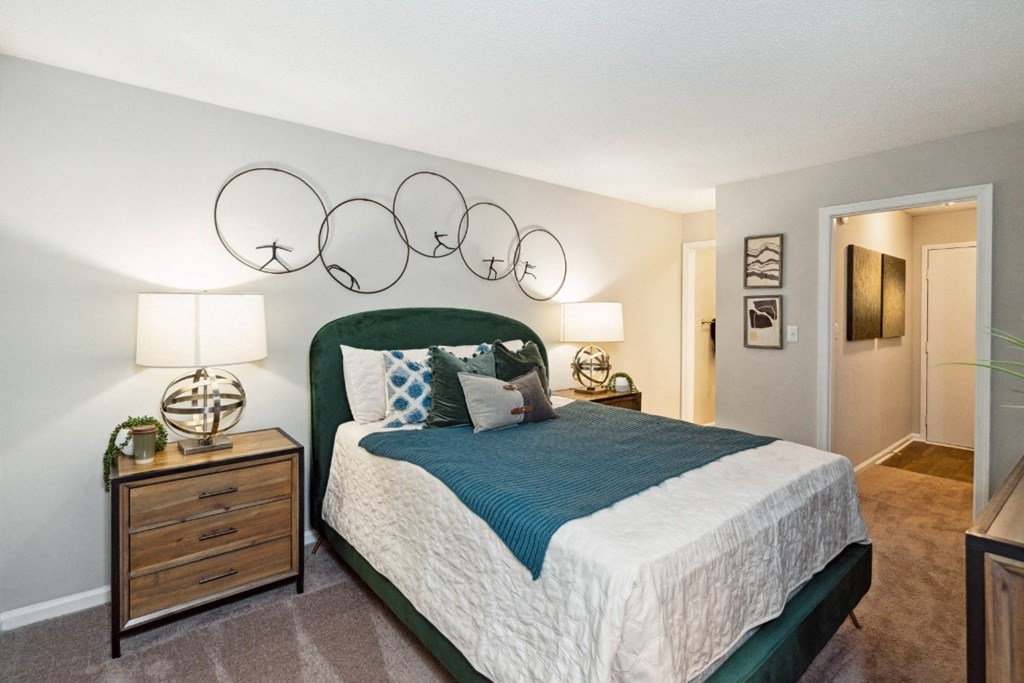 a bedroom with a bed and a nightstand with two lamps a bedroom with a bed and a nightstand with two lamps at Park Ridge Estates, Durham, North Carolina