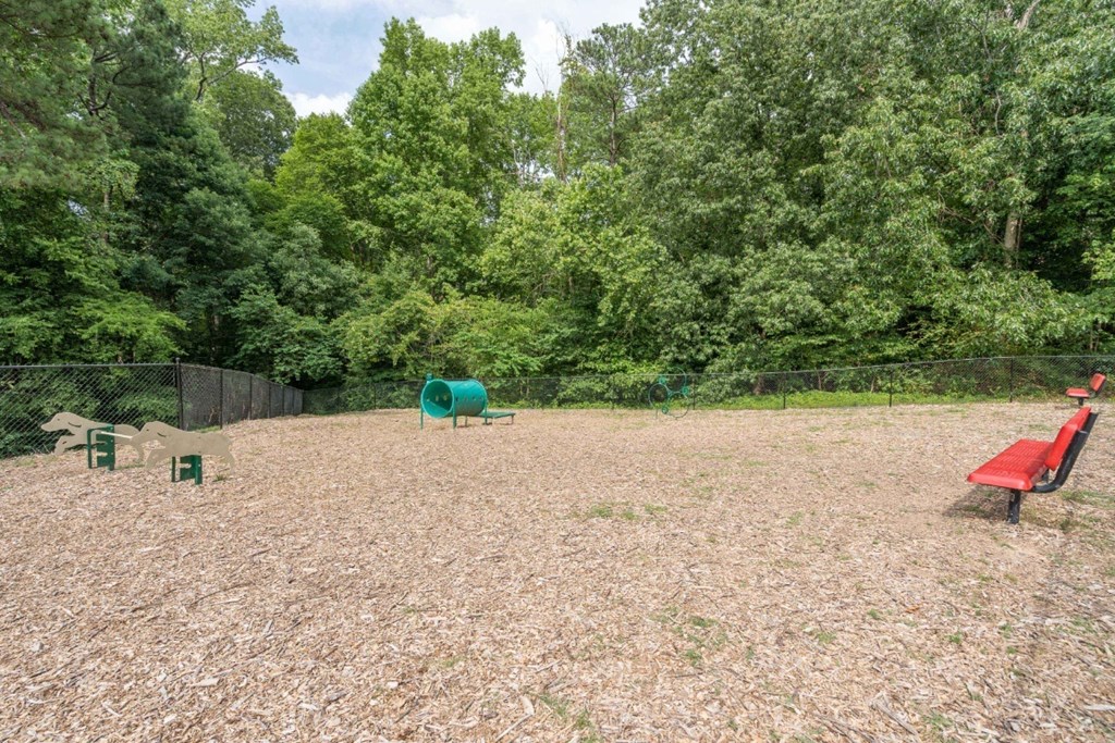 a large fenced in area with a picnic table and a red bench  at Park Ridge Estates, Durham, NC, 27713