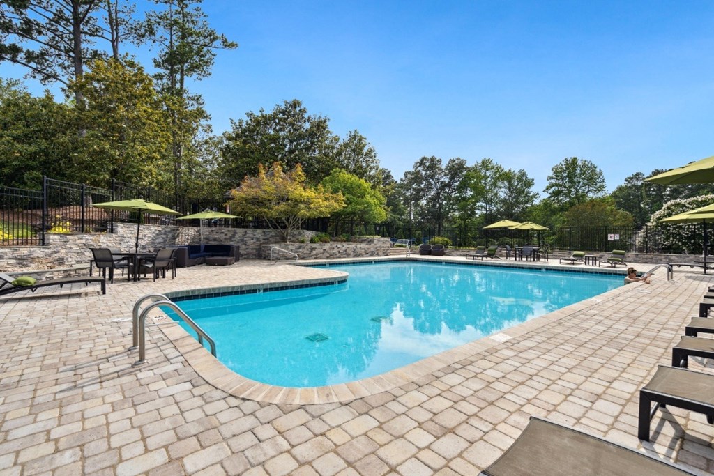 a resort style swimming pool with lounge chairs and umbrellas a resort style swimming pool with lounge chairs and umbrellas at Park Ridge Estates, Durham