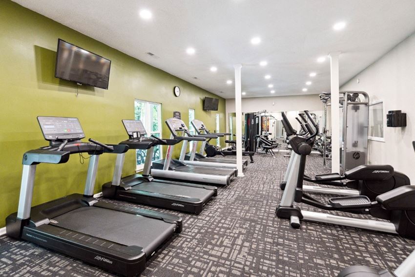 a gym with cardio equipment and a flat screen tv - Photo Gallery