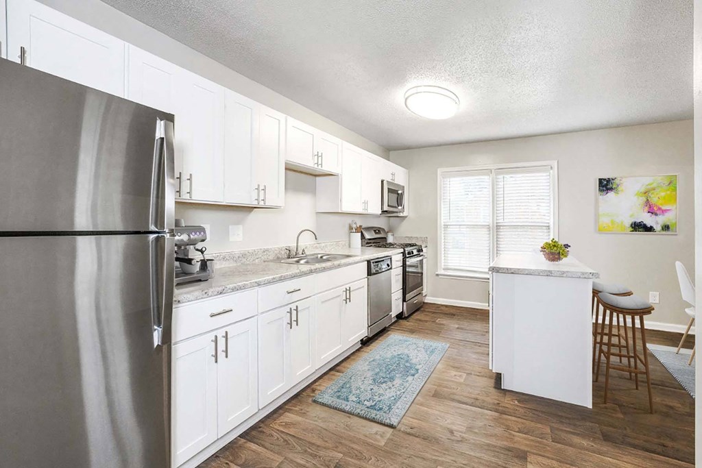 Open concept kitchen with quartz countertops and island seating at Hyde Park Townhomes, PRG Real Estate Management, Chester, 23831
