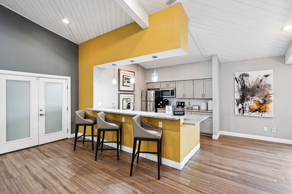 a kitchen and dining area with a yellow accent wall at The Reserve At Barry Apartments, Kansas City, Missouri
