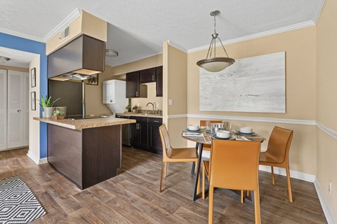 A kitchen with a table and chairs in front of it.