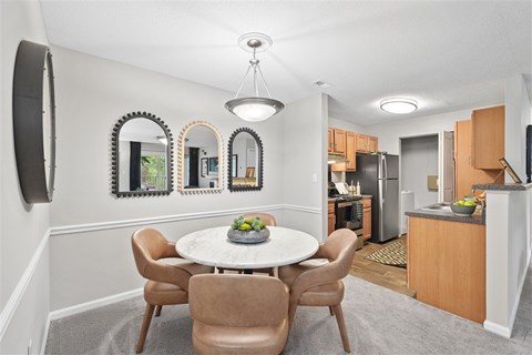 A dining room with a table and chairs.