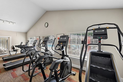 A gym with treadmills, exercise bikes, and elliptical machines.