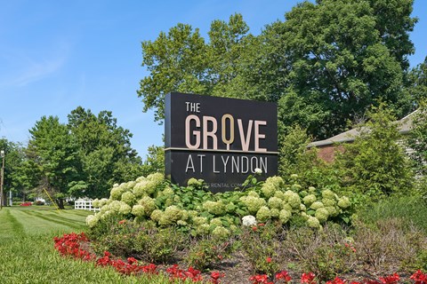 A sign that says "The Grove at Lyndon" is surrounded by flowers.